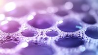 Abstract purple soap bubbles with foam texture creating dreamy bokeh effect for spa wellness beauty cosmetic backgrounds and relaxation themes.
