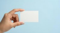 Hand holding blank white business card against light blue background, ready for custom branding and contact information design.
