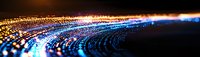 Glowing blue and orange light waves form dynamic circular pattern against dark background, creating futuristic technology visualization effect.