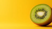 Fresh kiwi fruit slice showing green flesh and black seeds on bright yellow background with copy space for healthy eating and nutrition concepts.