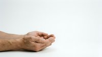 Cupped hands of an elderly Caucasian man held together in a giving or receiving gesture against a white background.