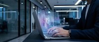 Businessman using laptop with digital holographic interface displaying data analytics and futuristic technology in modern office environment.