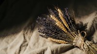 Rustic wheat and lavender bundle tied with twine on burlap fabric creating farmhouse decor arrangement for natural home styling and country kitchen design.