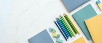 Colorful school supplies with pencils, notebooks and erasers arranged on white background for education and creative projects.