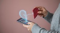 Woman holding smartphone with glowing heart icon and red paper heart, digital love connection concept for Valentine's Day and online dating apps.