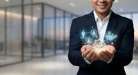 Professional Asian businessman in dark suit holding glowing digital network icons representing connectivity and technology in modern office environment.
