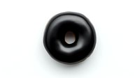 Black glazed donut with hole isolated on white background for bakery menu design and food advertising projects.