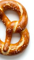 Freshly baked pretzel with coarse salt crystals on white background, isolated for bakery, food packaging, menu design, and culinary projects.