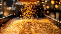 Golden grains falling in industrial processing facility with bokeh light effects, close-up view of agricultural production showing cereal manufacturing process.