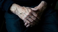 Elderly hands clasped together showing wrinkled skin and age spots, representing senior care, aging process, wisdom, and life experience in healthcare.