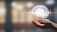 Human hands holding glowing brain hologram with neural network connections representing artificial intelligence, machine learning and cognitive technology innovation.