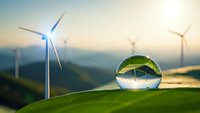 Crystal sphere reflecting wind turbines on green hills at sunrise showcasing renewable energy and environmental sustainability concepts.