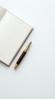 Open notebook with blank pages and vintage fountain pen with dark wood barrel and gold trim on white background for writing and correspondence.