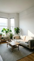 Bright, airy living room with gray upholstered sofa, wooden coffee table, potted plants on windowsill, and natural light from large windows. Scandinavian interior design style for home decor and lifestyle content.