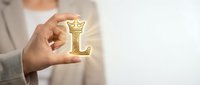 Person holding golden letter L symbol, representing leadership, learning, or luxury concepts for business and corporate branding applications.