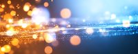 Abstract glowing light particles and bokeh effect on dark blue background with golden and orange sparkles creating magical atmosphere.