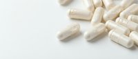 White capsules scattered on clean background for pharmaceutical and healthcare design projects.