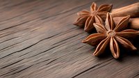Aromatic star anise spices and cinnamon sticks arranged on rustic wooden surface for culinary cooking and baking recipes.