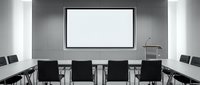 Modern conference room with blank projection screen, white walls, and black chairs arranged around table for business meetings and presentations.