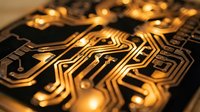 Golden circuit board with intricate electronic pathways and glowing connections showcasing modern technology and digital innovation for tech presentations.