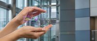 Hands holding smartphone with holographic digital interface displaying futuristic technology in modern office building for business innovation and connectivity.