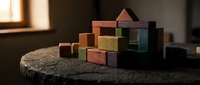 Colorful wooden building blocks stacked on dark surface creating geometric arrangement for educational play and creative construction activities.