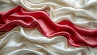 Flowing red and white silk fabric with elegant waves and smooth texture creating luxurious abstract background for premium design projects.