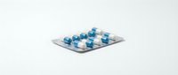 Blister pack of blue and white capsule pills isolated on white background, ready for pharmaceutical, medical, and healthcare design projects.