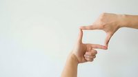 Caucasian male hand forming rectangular frame gesture with fingers against neutral background for creative composition and framing concepts.