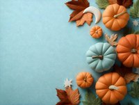 Seasonal autumn composition with orange and blue pumpkins, maple leaves on turquoise background with copy space for text.