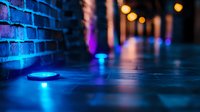 Atmospheric urban night scene with neon blue lights illuminating brick wall and ground, creating moody reflections with bokeh effects in background.