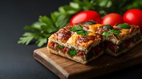 Homemade focaccia bread with cherry tomatoes, herbs and melted cheese served on wooden cutting board against dark background. Fresh Italian cuisine.