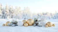 Festive gold and white ornaments with frosted evergreen branches arranged on snow, winter holiday decoration and seasonal celebration background.