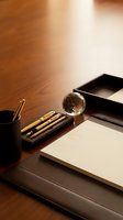 Elegant executive desk setup with luxury pens, crystal paperweight, leather accessories and warm lighting for professional office workspace design.