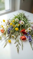 Vibrant wildflower and herb bouquet arranged on white surface near window, featuring yellow button flowers, daisies, red poppies, and purple lavender stems for floral design and decoration.