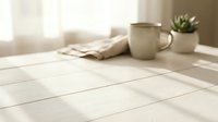 Cozy morning scene with white coffee mug and small plant on wooden table near bright window creating warm natural lighting atmosphere for home decor concepts.