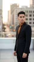 Young Hispanic businessman in black suit standing confidently on urban rooftop at sunset with city skyline background for corporate and professional use.