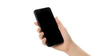 Hand holding black smartphone with blank screen isolated on white background for mockup and app presentation designs.