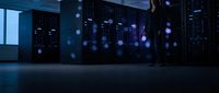 Modern data center server room with glowing blue lights and bokeh effects creating futuristic technology atmosphere for business presentations.
