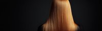 Long straight copper brown hair from back view against dark background, demonstrating healthy, smooth, shiny hair texture for beauty and haircare advertising.