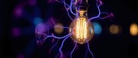 Vintage Edison bulb surrounded by electric lightning bolts and plasma energy on dark background. Creative concept for innovation and power generation.