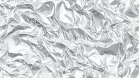 Crumpled silver metallic foil texture with reflective wrinkled surface creating abstract light patterns for modern design backgrounds and luxury packaging.