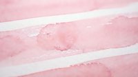 Abstract pink watercolor brush strokes on white paper creating soft flowing horizontal bands with organic texture for artistic backgrounds.