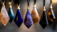 Colorful crystal pendants on black cords with gold findings, featuring purple, blue, and pink gemstones in geometric shapes against blurred background. Mystical jewelry display.