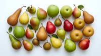 Fresh organic pears and apples collection on white background. Variety of colorful autumn fruits including green, red, yellow varieties isolated for healthy eating.