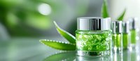 Glass jar with green organic cosmetic gel and aloe vera leaves on light background. Natural skincare and beauty product photography for wellness industry.