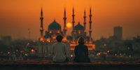Silhouettes of two people sitting peacefully watching sunset behind illuminated mosque with minarets creating serene spiritual atmosphere for meditation.