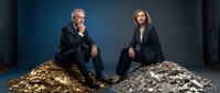 Professional business partners sitting on piles of shredded paper documents in corporate office setting for financial consulting concepts.