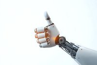 Robotic arm showing thumbs up gesture against white background, metallic and white mechanical hand with copper accents demonstrating positive approval signal.