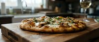 Freshly baked focaccia bread with herbs and olive oil on wooden board in modern kitchen setting, ready for serving or dining.